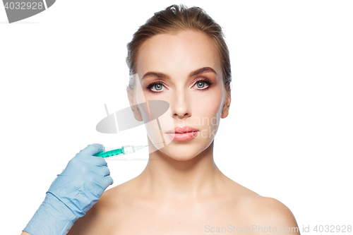 Image of woman face and hand with syringe making injection