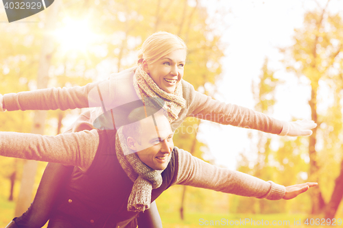 Image of smiling couple having fun in autumn park