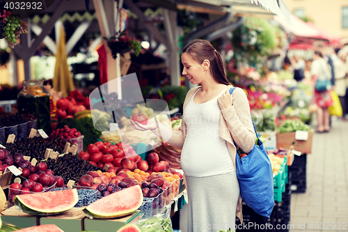 Image of pregnant woman choosing food at street market