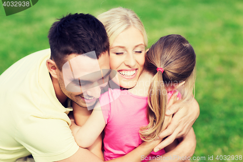 Image of happy family hugging outdoors