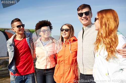 Image of happy teenage friends in shades talking on street