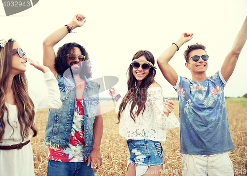 Image of happy young hippie friends dancing outdoors