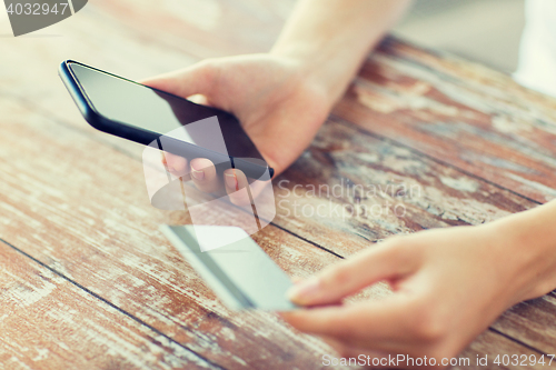 Image of close up of hands with smart phone and credit card