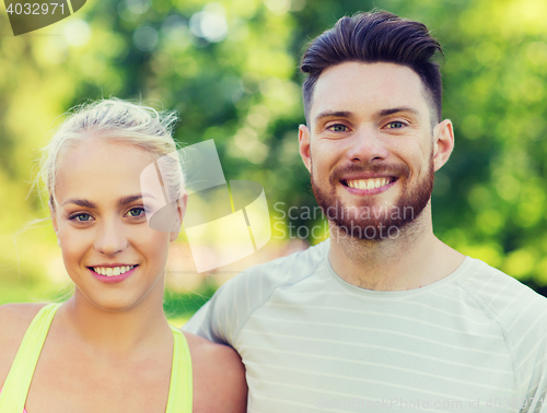 Image of happy friends or sportsmen couple hugging outdoors