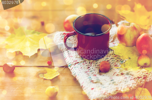 Image of close up of tea cup on table with autumn leaves