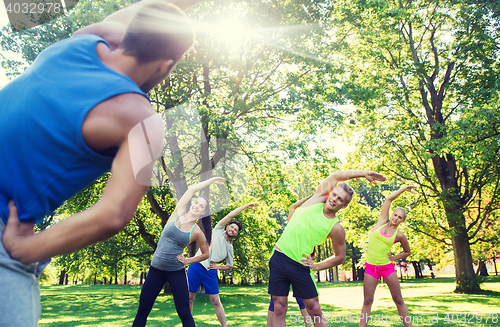 Image of group of friends or sportsmen exercising outdoors