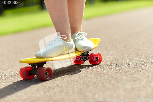 Image of close up of female feet riding short skateboard