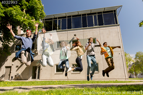 Image of happy teenage students or friends jumping outdoors