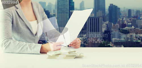 Image of close up of female hands with money and tax report