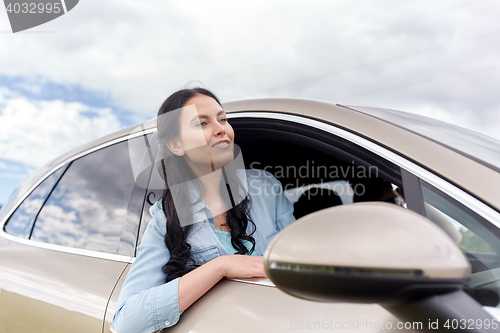Image of happy young woman driving in car