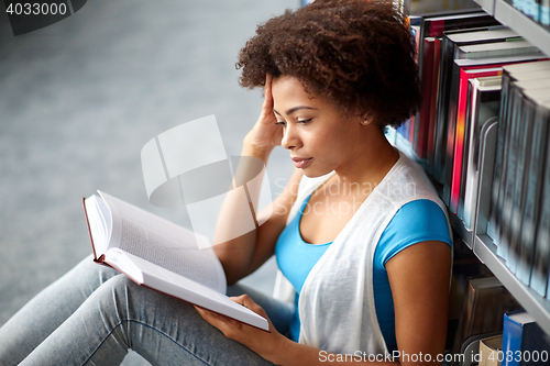 Image of african student girl reading book at library