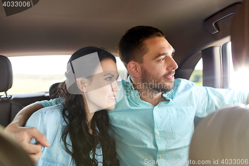 Image of happy man and woman hugging in car