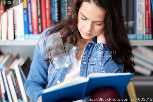 Image of high school student girl reading book at library