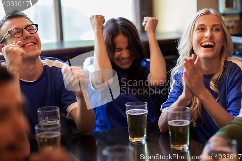 Image of football fans or friends with beer at sport bar