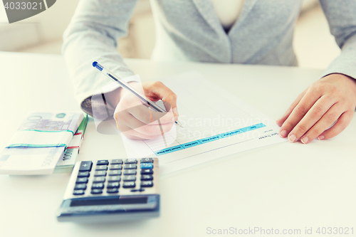 Image of close up of hands counting money with calculator