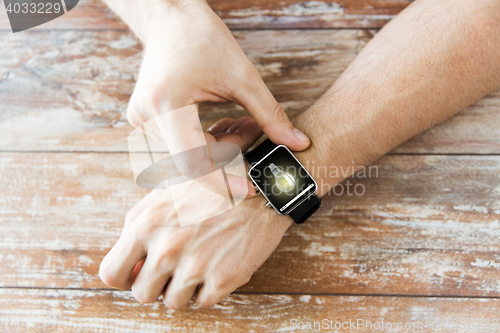 Image of close up of hands with light bulb on smart watch