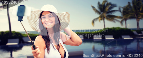 Image of smiling young woman taking selfie with smartphone