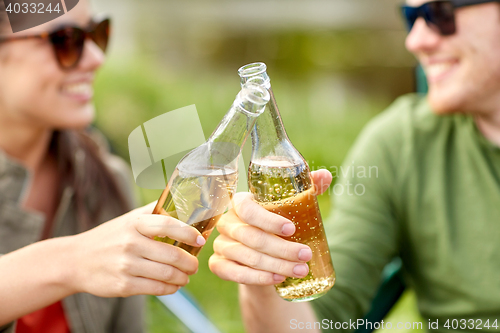 Image of close up of happy couple clinking drinks outdoors