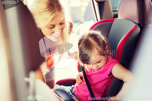 Image of happy mother fastening child with car seat belt