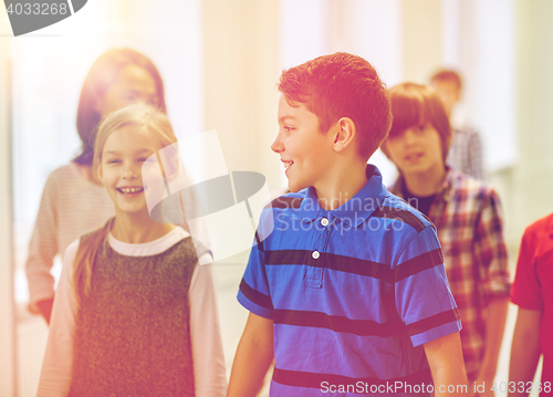 Image of group of smiling school kids walking in corridor