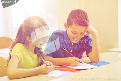 Image of group of school kids writing test in classroom