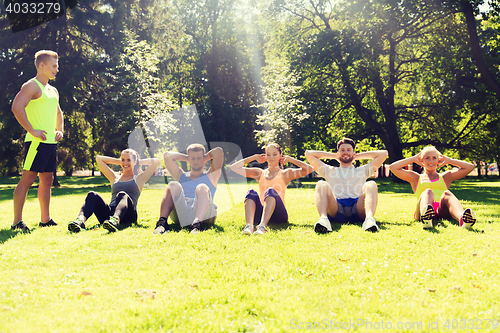 Image of group of friends or sportsmen exercising outdoors