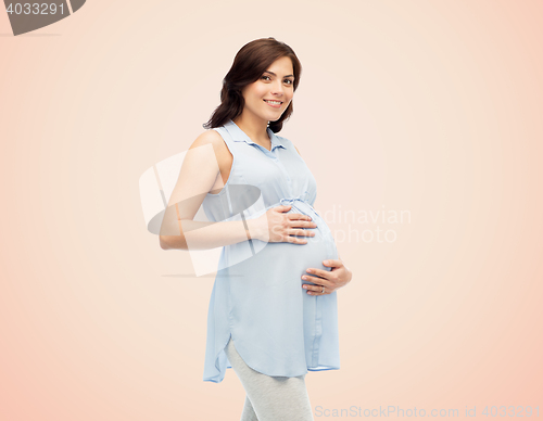 Image of happy pregnant woman touching her big belly