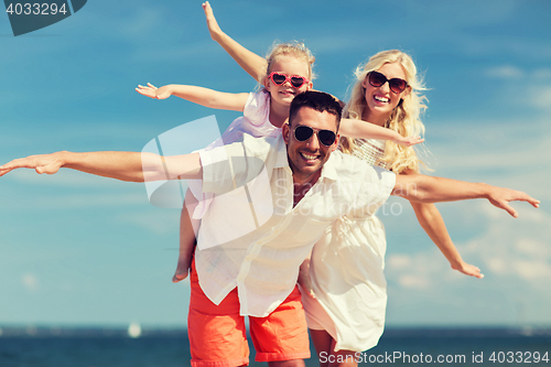 Image of happy family having fun on summer beach