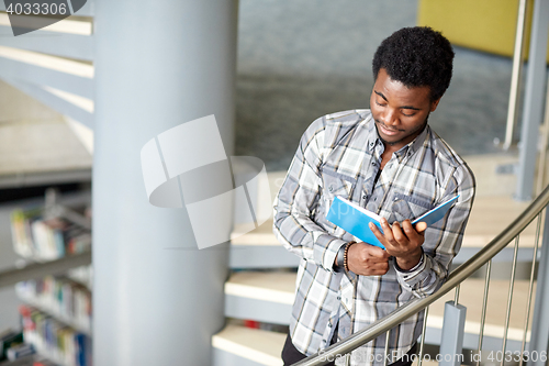 Image of african student boy or man reading book at library