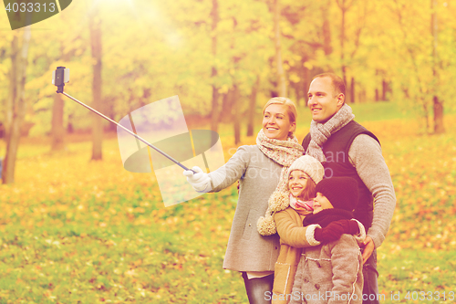 Image of happy family with smartphone and monopod in park