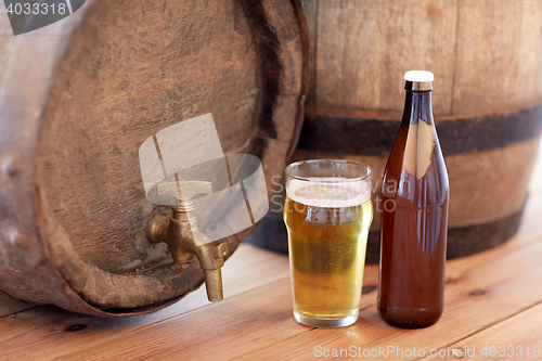 Image of close up of old beer barrel, glass and bottle