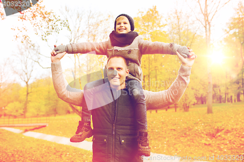 Image of happy family having fun in autumn park