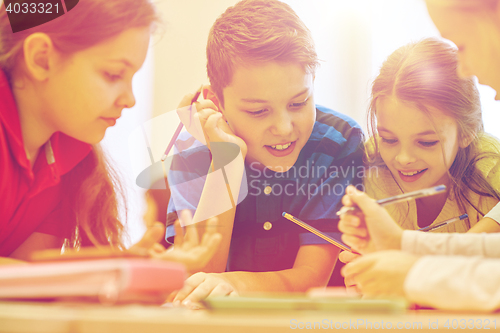 Image of group of students talking and writing at school