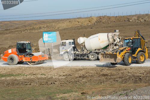 Image of Taman, Russia - March 8, 2016: Ice Rink, cement mixer and excavator are on the road leading to the bridge being built Kerch