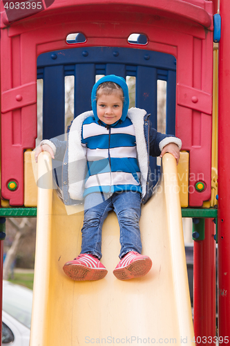 Image of Cheerful little girl goes for a drive on a hill on a cool spring day