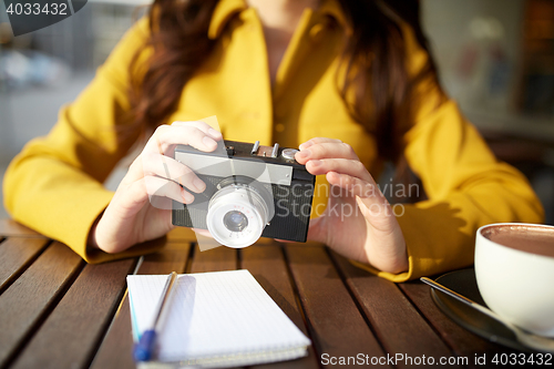 Image of close up of woman with camera at city cafe