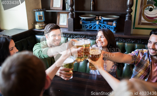 Image of happy friends drinking beer at bar or pub