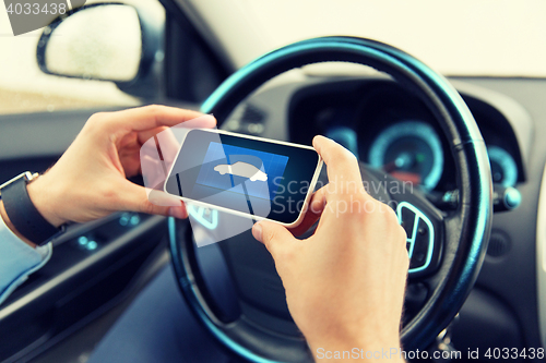 Image of close up of male hands with car icon on smartphone