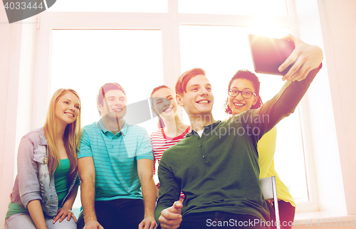 Image of smiling students making picture with tablet pc