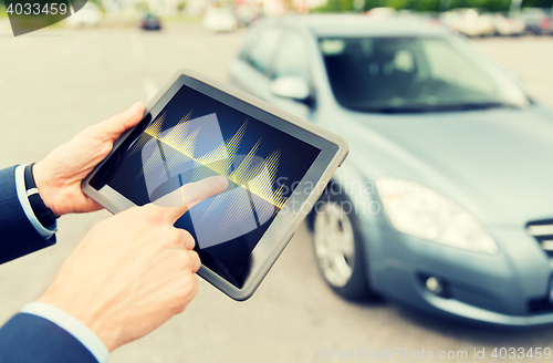 Image of close up of hands with diagram tablet pc and car