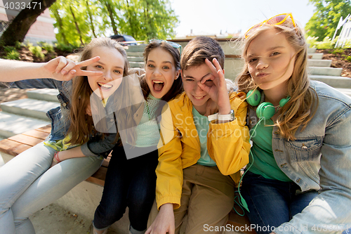 Image of happy teenage students or friends having fun