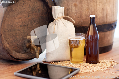 Image of close up of beer barrel, tablet pc and malt