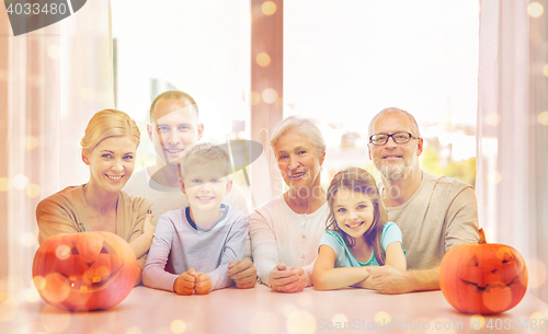 Image of happy family sitting with pumpkins at home