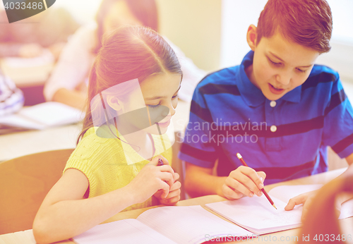 Image of group of school kids writing test in classroom