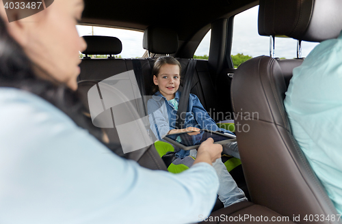 Image of happy family with tablet pc driving in car