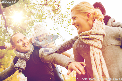 Image of happy family having fun in autumn park