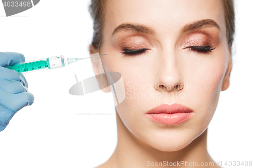 Image of woman face and hand with syringe making injection