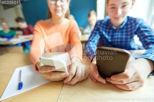Image of high school students with smartphones texting