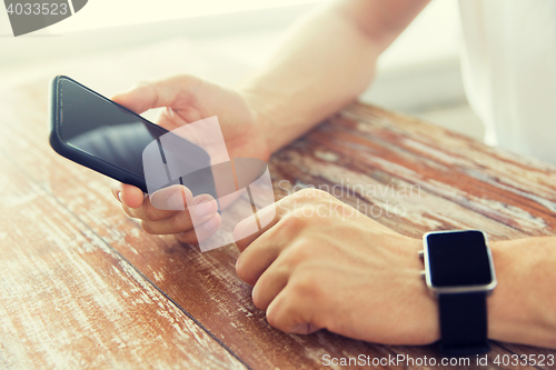 Image of close up of hands with smart phone and watch