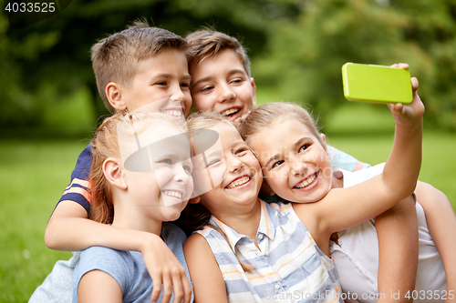 Image of happy kids or friends taking selfie in summer park